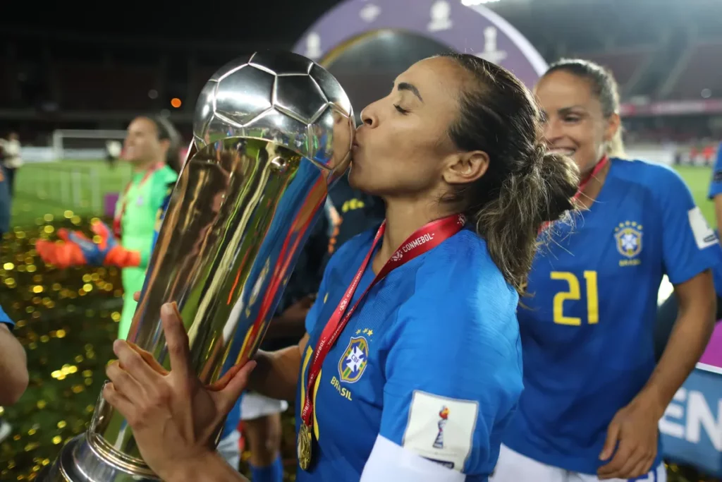 Jogadora Marta beijando troféu da Copa América