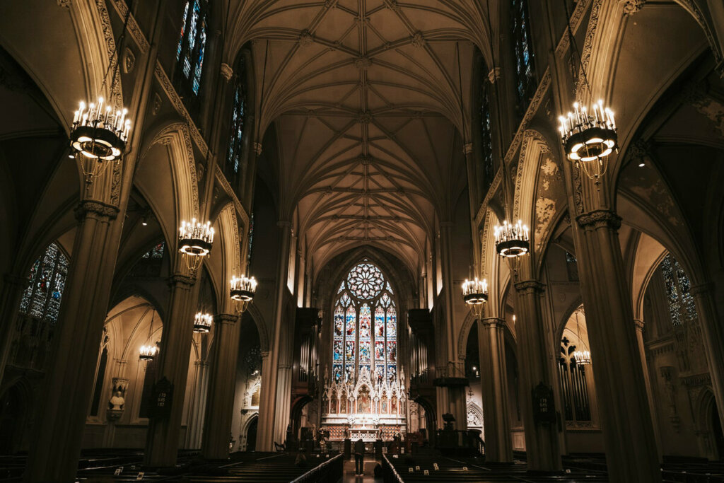 Imagem interna de uma igreja com arcos e vitrais