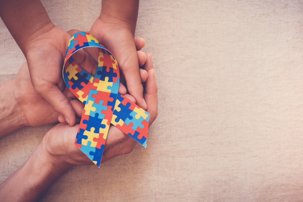 Mãos segurando fita quebra-cabeça para o Dia Mundial da Consciência do Autismo