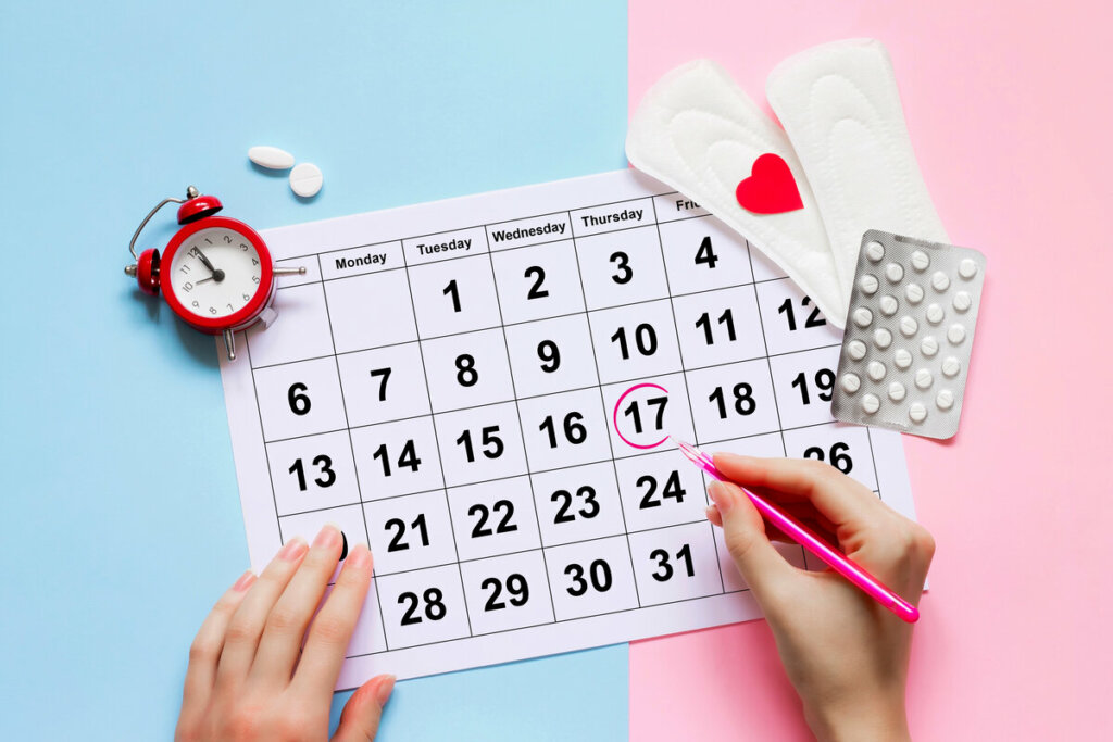 Mãos femininas preenchendo um calendário menstrual