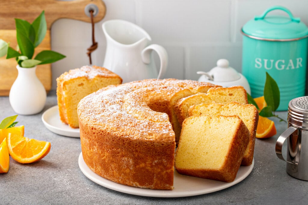 Bolo de laranja em cima de um prato branco cortado em pedaços