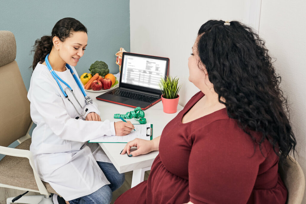 Mulher com sobrepeso conversando com médica