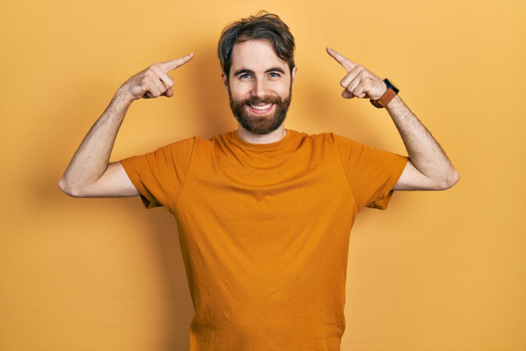 Homem sorrindo apontando para a cabeça