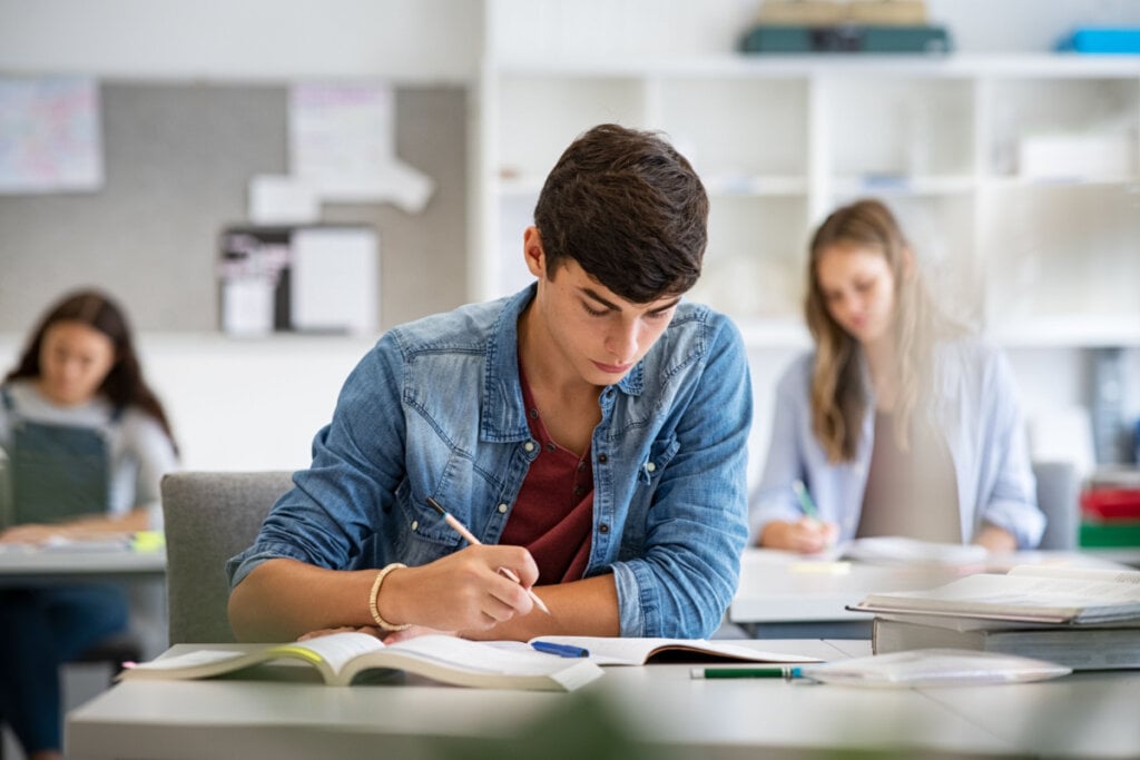 Jovem escrevendo redação durante prova