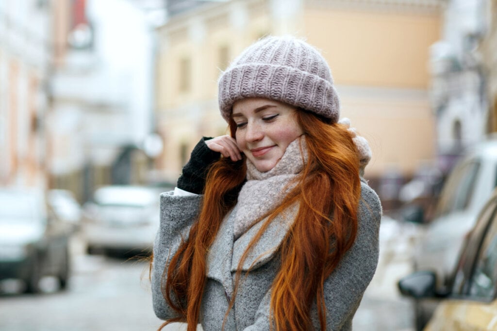 Mulher ruiva com gorro e roupas de inverno