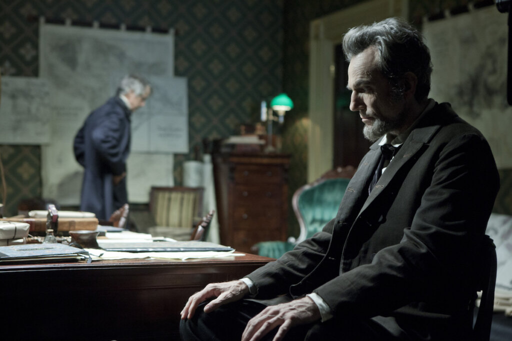 Cena do filme "Lincoln", em que o ex-presidente está sentado com olhar pensativo. 