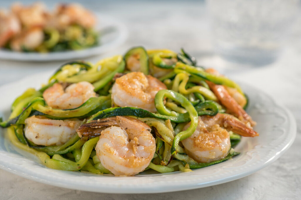 Prato branco com spaghetti de abobrinha com camarões