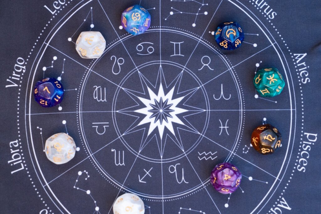 Mesa azul com um círculo com os doze signos do zodíaco e com pedras sobre ela