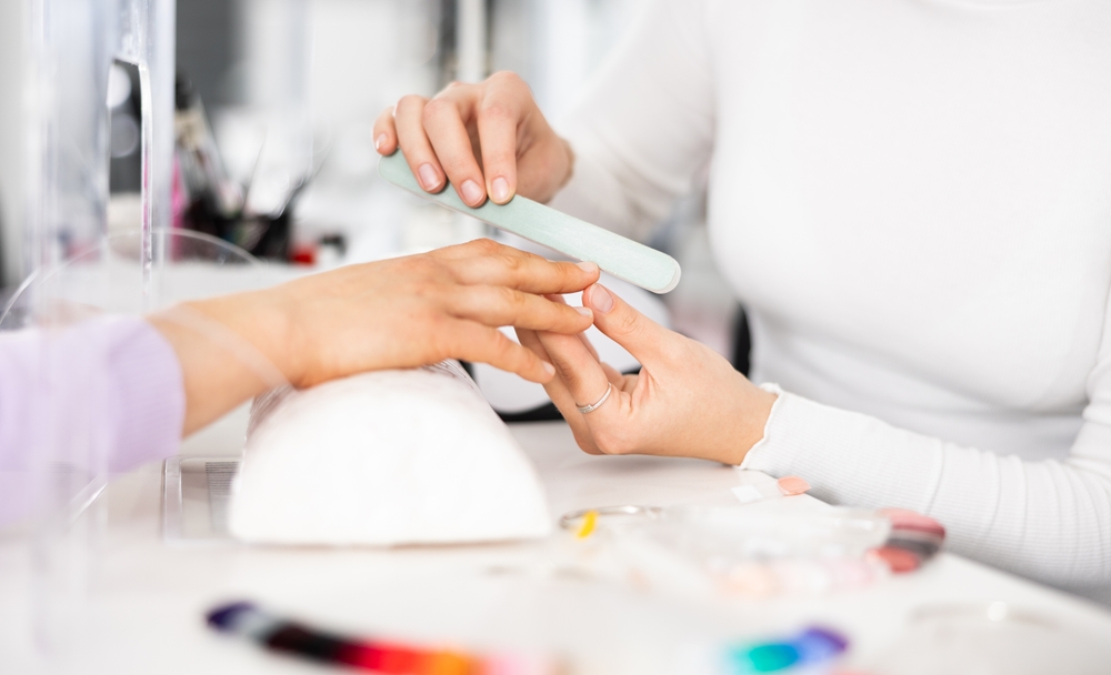 Manicure fazendo manutenção do alongamento de unhas da cliente