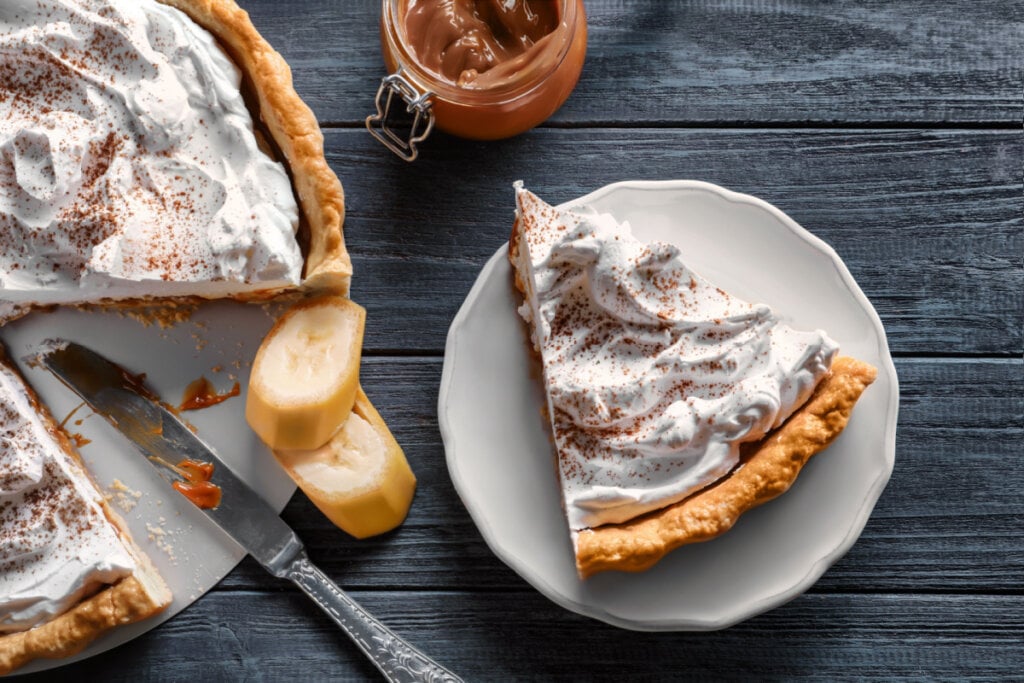 Fatia de torta de Banoffee em mesa de madeira com tom de grafite