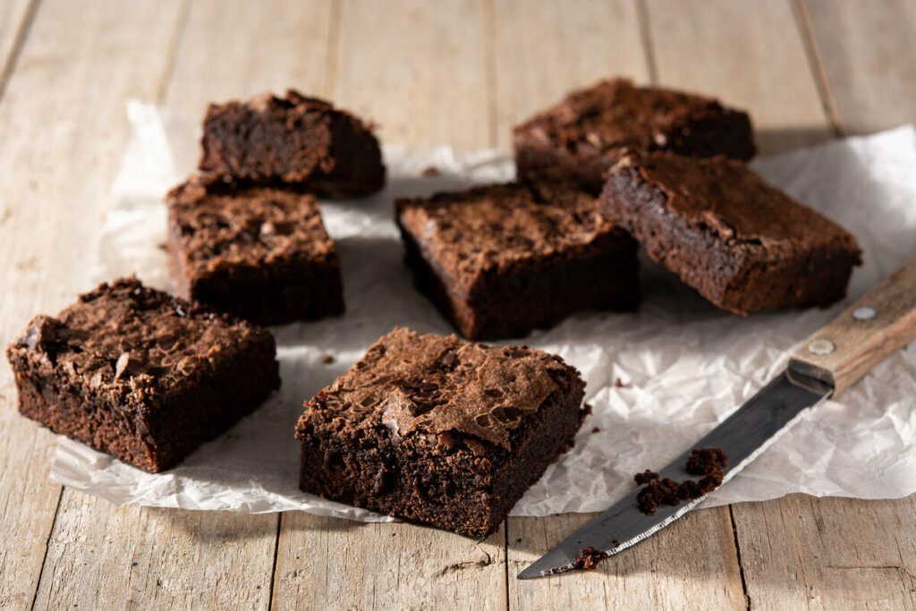 Brownies em cima de um papel de manteiga com uma faca ao lado