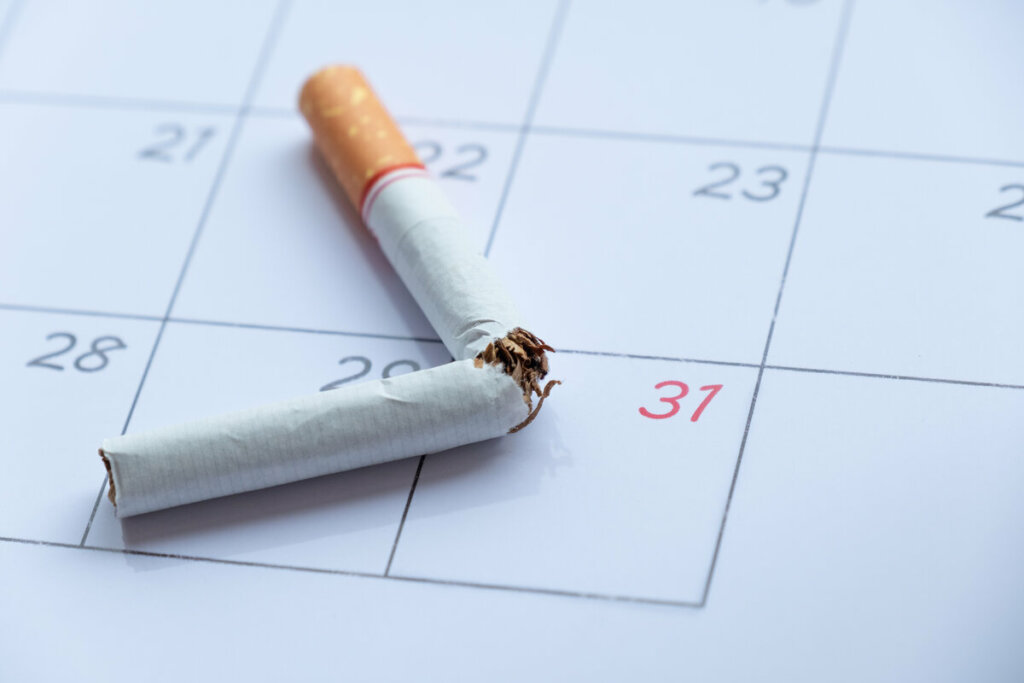 Cigarro cortado ao meio em cima de um calendário 