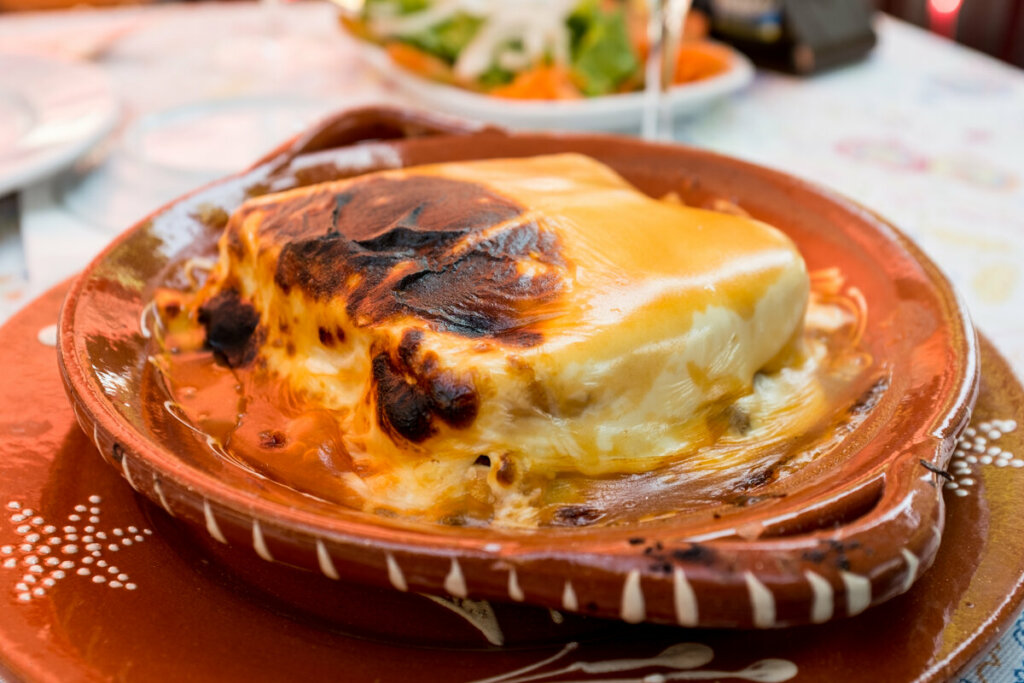 Prato marrom com sanduíche francesinha, típico de Portugal