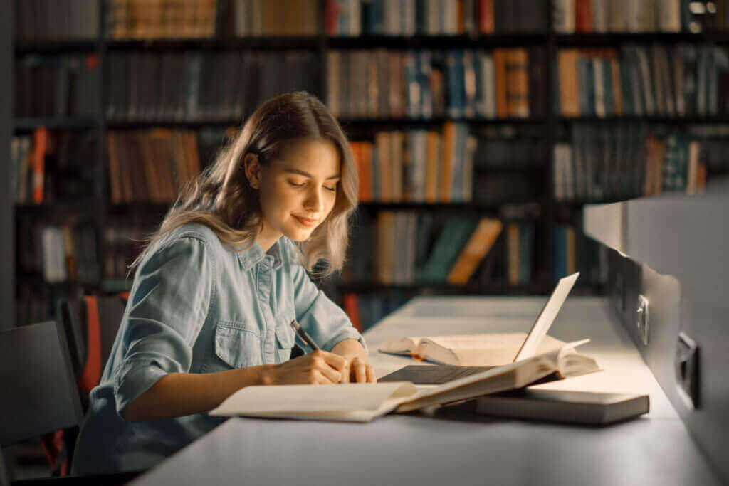 Menina estudando com livros ao seu lado