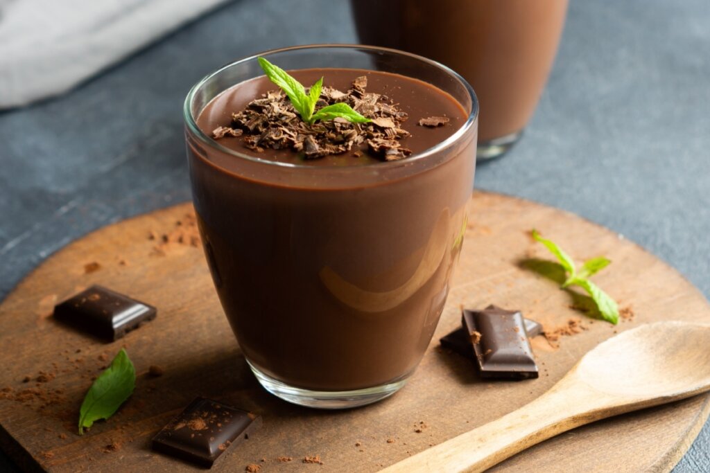 Copo de vidro com musse de chocolate decorado com raspas de chocolate e folha de hortelã 