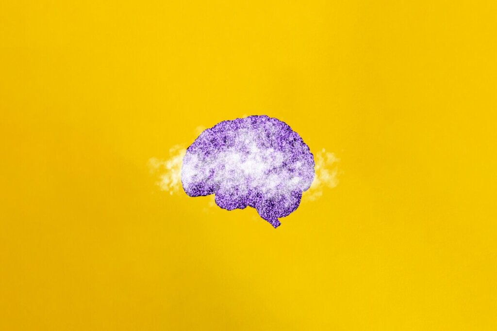 Ilustração de um cérebro roxo em um fundo amarelo com névoa sobre ele