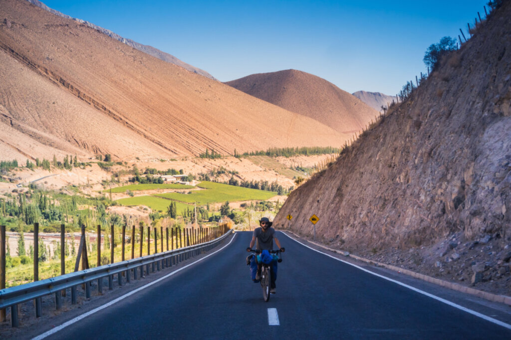 Homem andando de moto com vista para Paihuano, no Chile