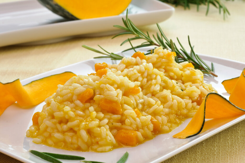 Prato branco com risoto de abóbora em cima de uma mesa