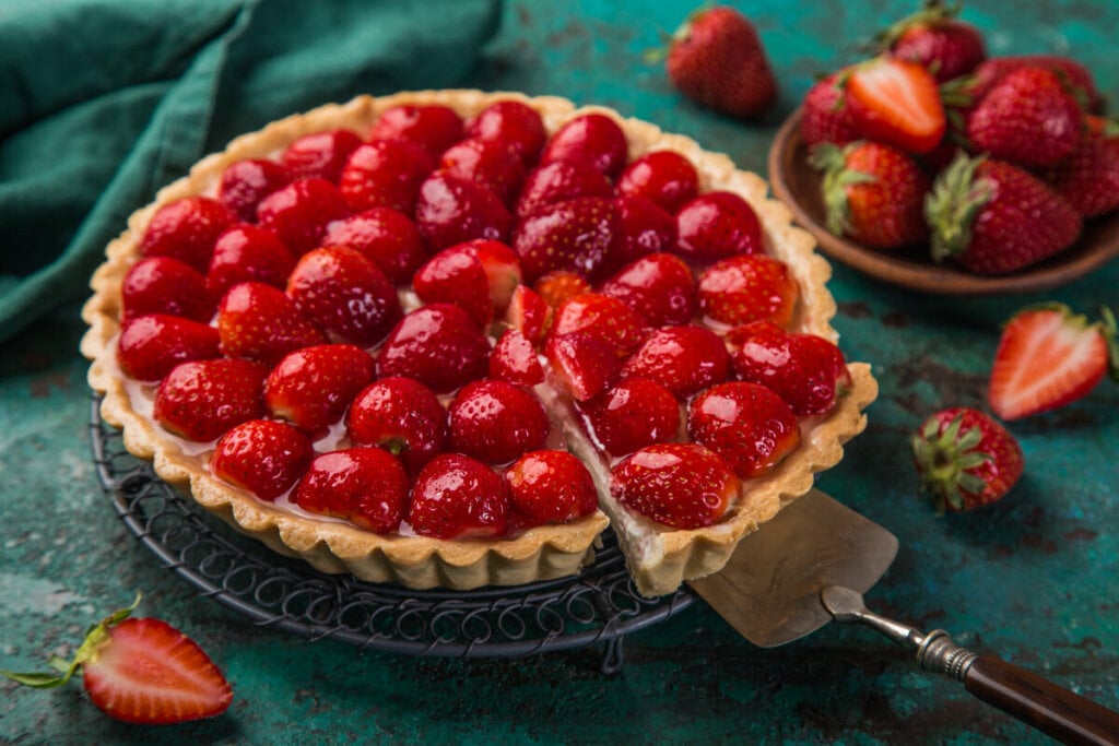 Espátula cortando o predaço de uma torta de morango