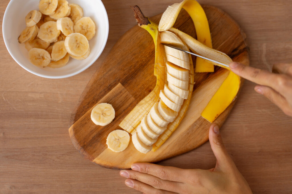 Mulher cortando fatias de banana
