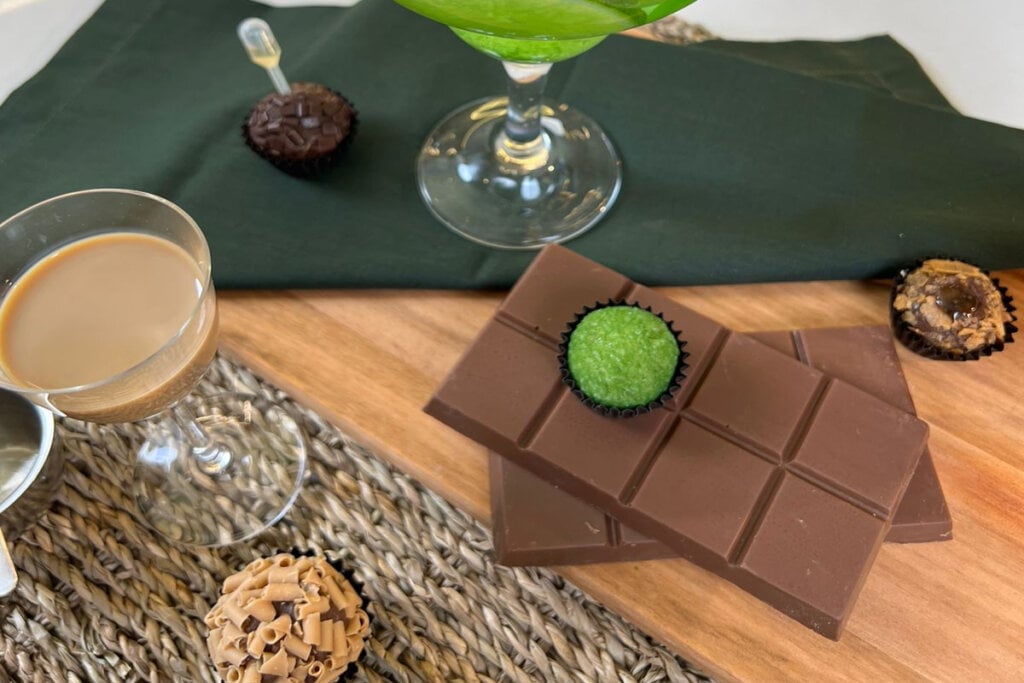 Brigadeiro de caipirinha em cima de uma barra de chocolate com uma caipirinha ao lado