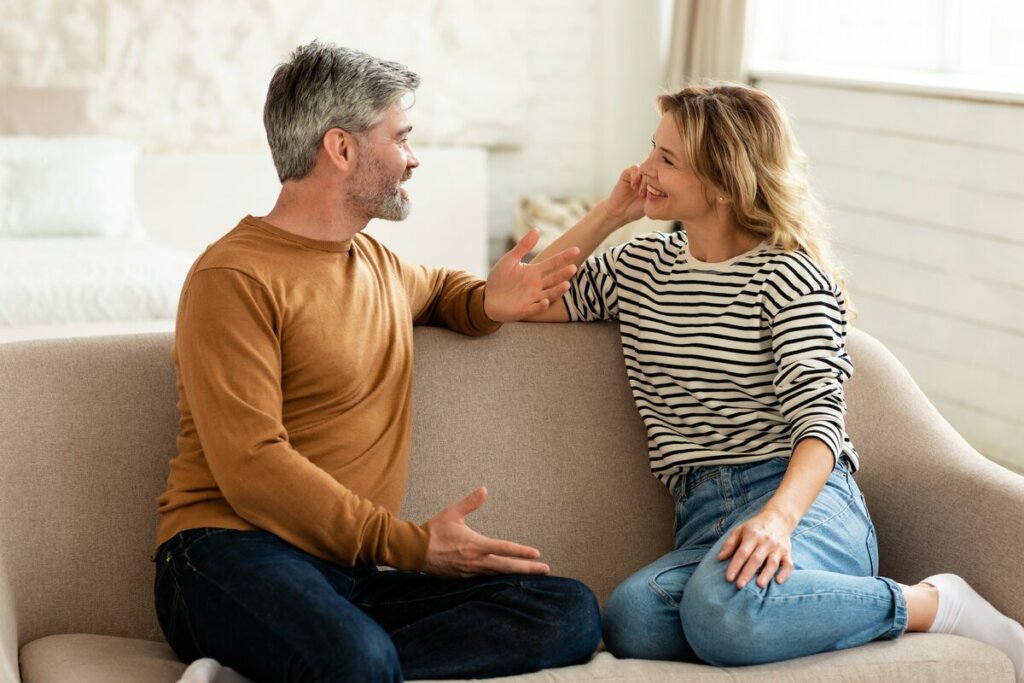 Homem e mulher sentados em um sofá bege conversando