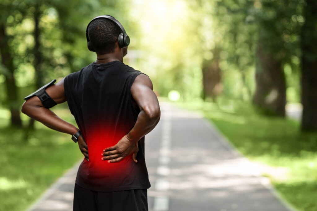Esportista com dor nas costas durante caminhada
