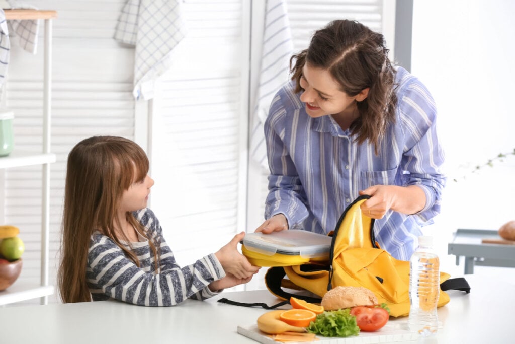 Mãe e filha preparando lancheiras juntas