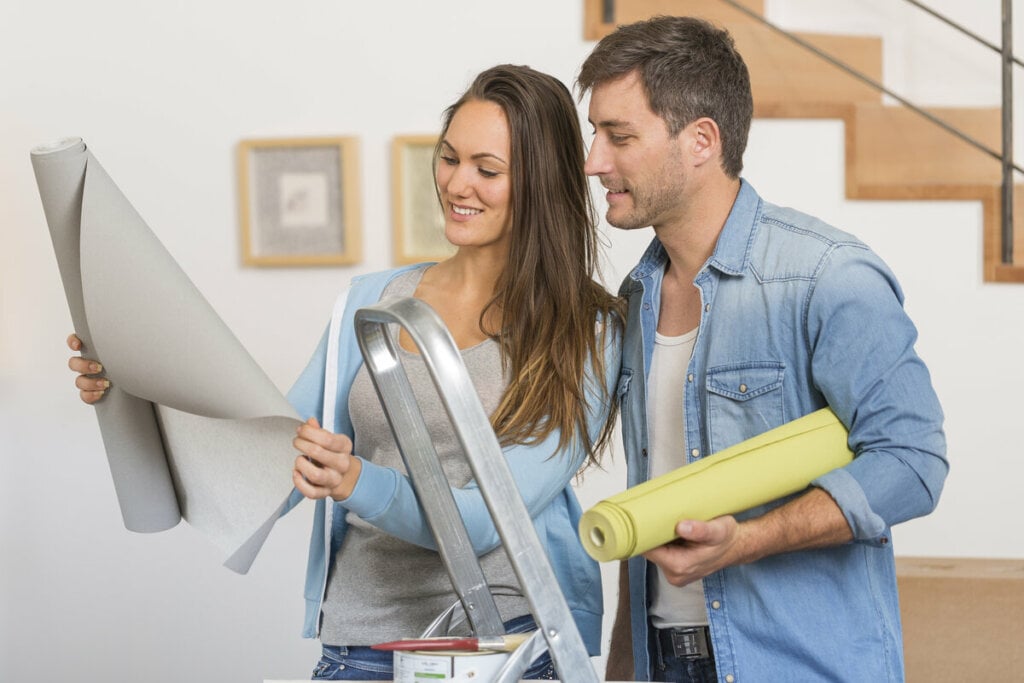 Mulher e homem olhando para um projeto de decoração e sorrindo