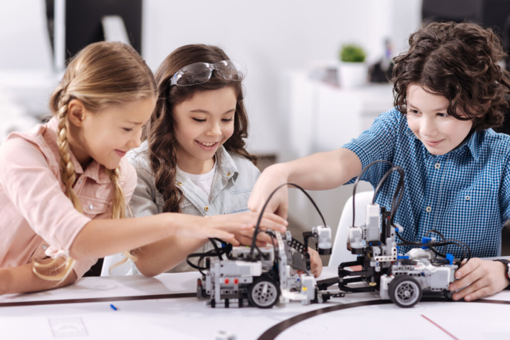 Crianças alegres que trabalham no projeto de robótica da escola