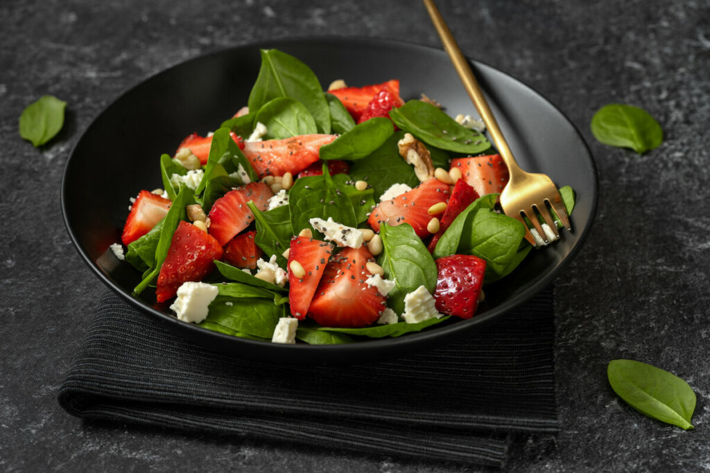 Prato preto com salada de espinafre com morango e queijo feta