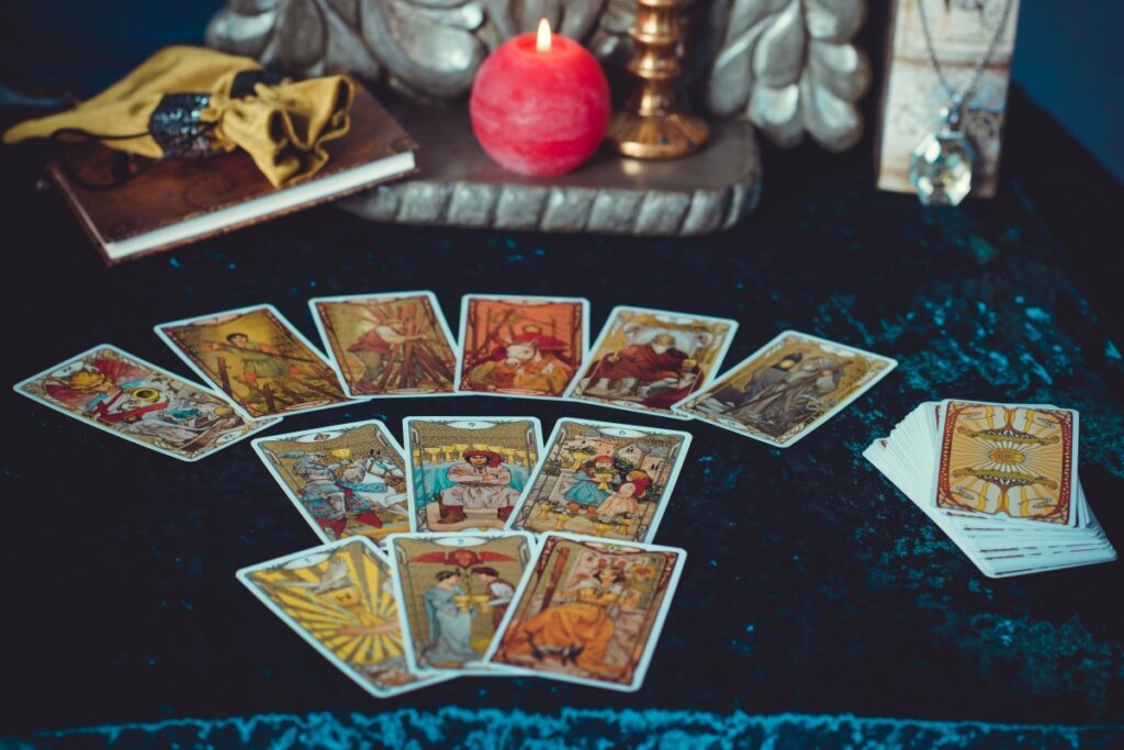 Cartas de tarot em cima de uma mesa com pano azul e velas
