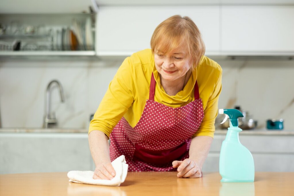 Mulher limpando uma mesa com pano branco