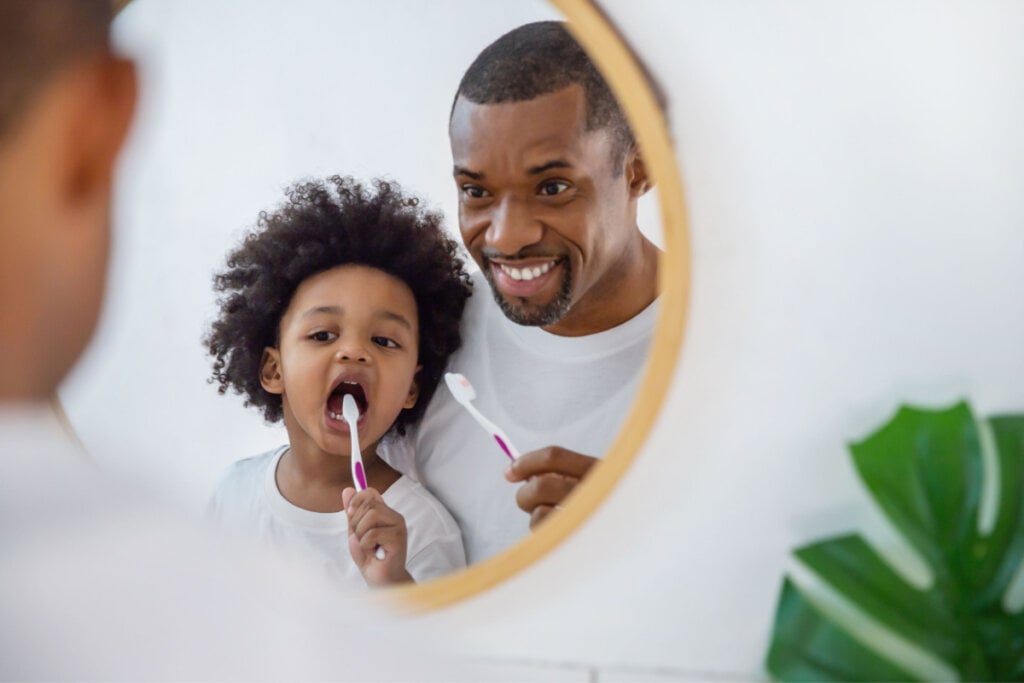 Pai e filho escovando os dentes