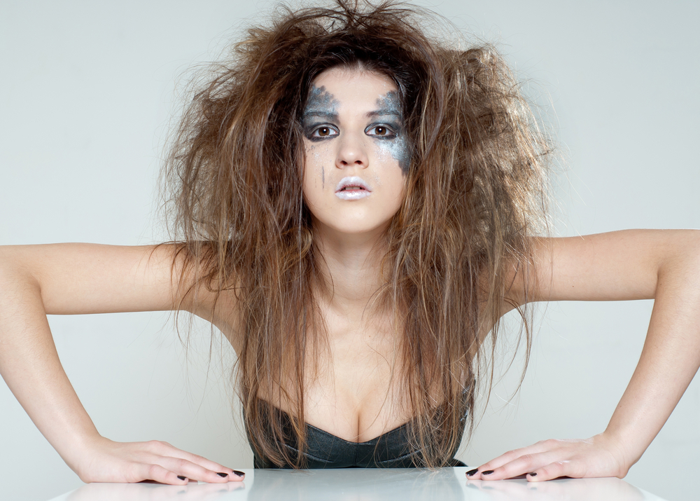Mulher maquiada com cabelo bagunçado no estilo messy hair