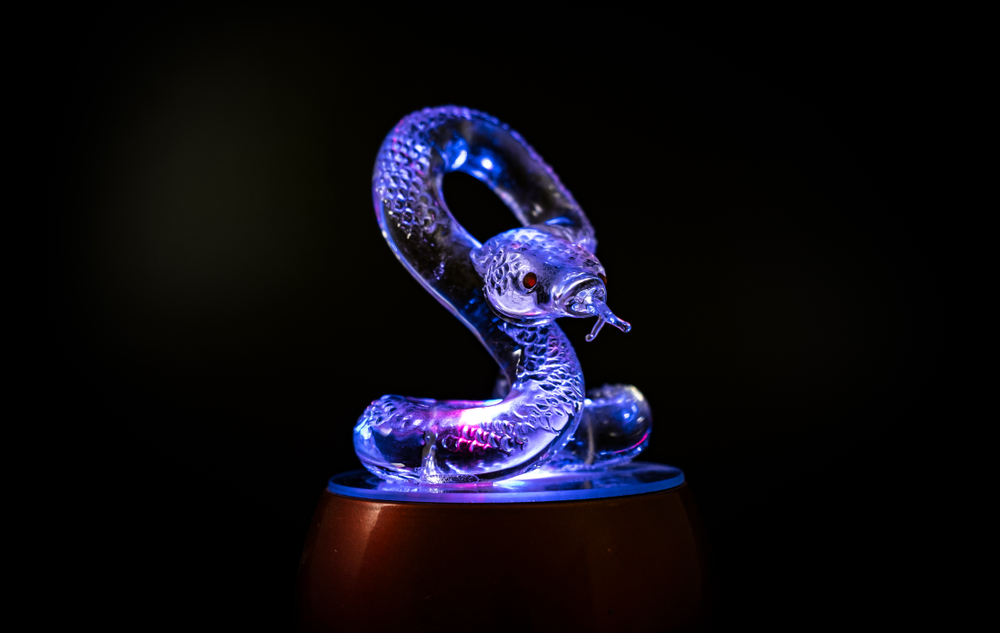 Estatueta de cobra em vidro com iluminação azul
