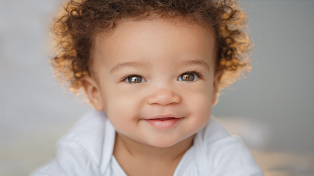 Bebê de cabelo cacheado sorrindo