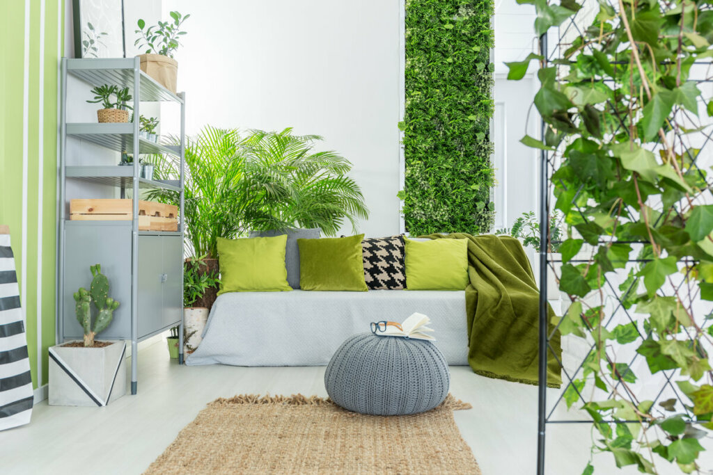 Sala de estar com jardim vertical, sofá cinza e tapete bege