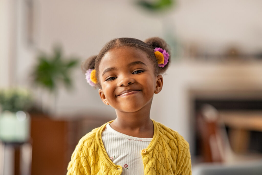 Menina sorrindo com cabelo preso e flores no cabelo