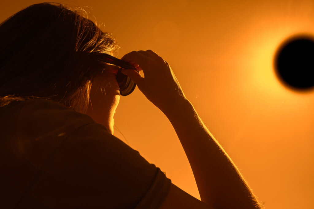 Mulher de óculos olhando para o eclipse