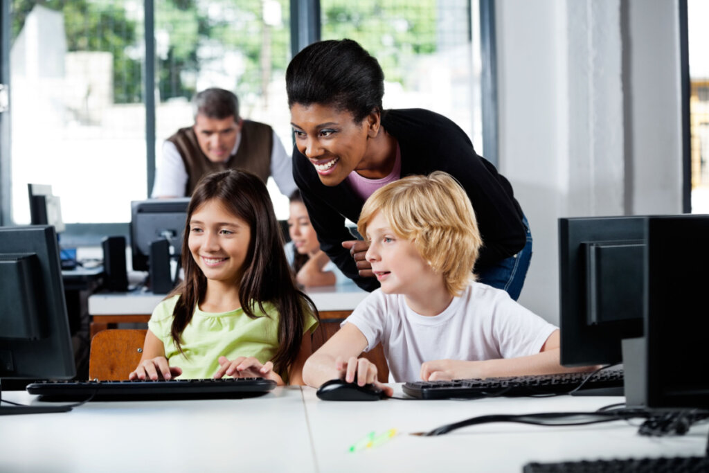 Crianças e professores em uma sala de informática