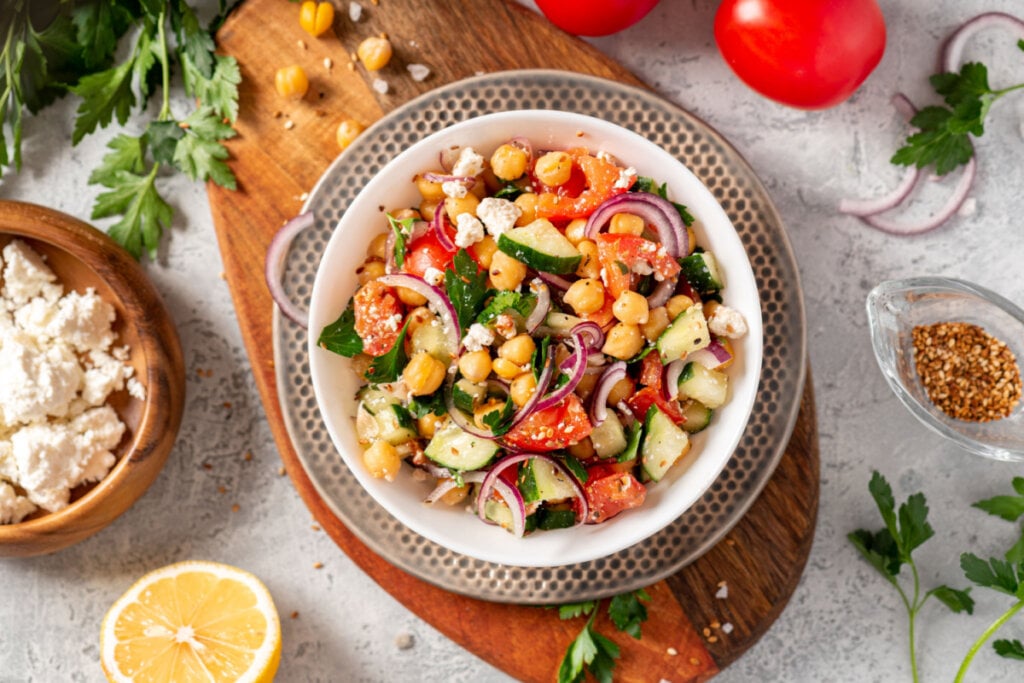 Prato de salada de grão de bico com ingredientes ao redor