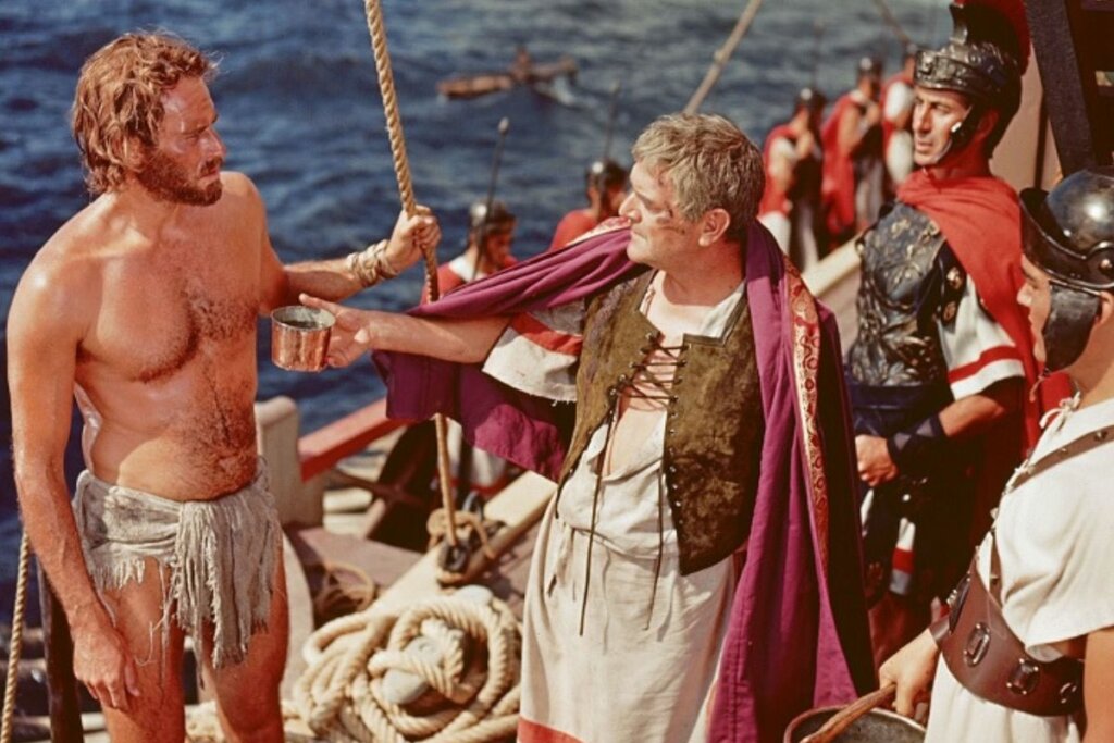 Protagonista Ben-Hur conversando com um romano no filme 'Ben-Hur'