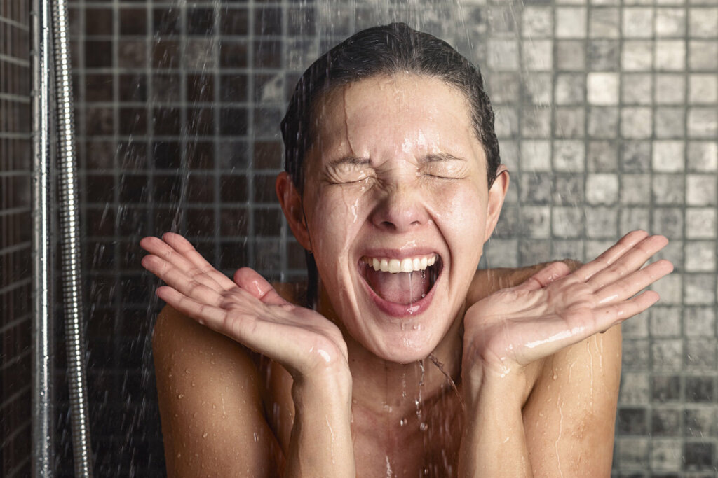 Mulher sorrindo tomando banho em um chuveiro