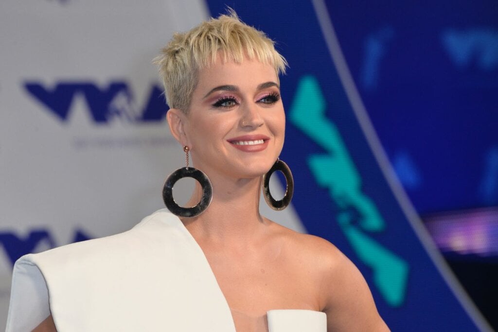 Cantora Katy Perry com cabelo loiro curto usando vestido branco