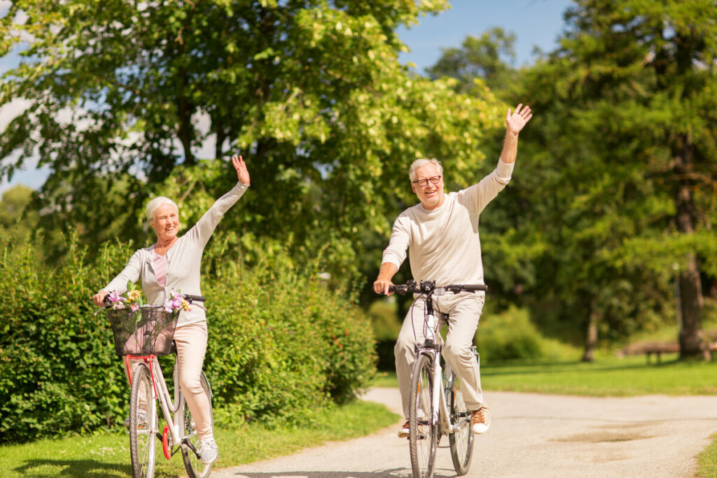 Homem e mulher de meia idade andando de bicicleta em um parque