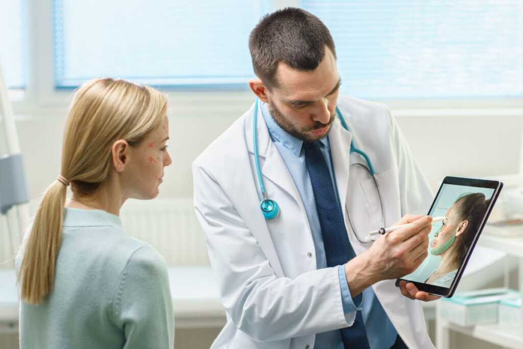 Médico mostrando imagem em tablet de rosto para a paciente