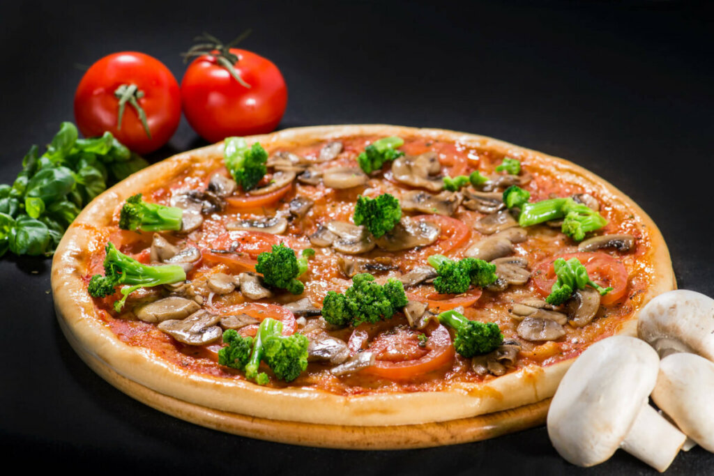 Pizza com molho de tomate, brócolis, tomate e cogumelo