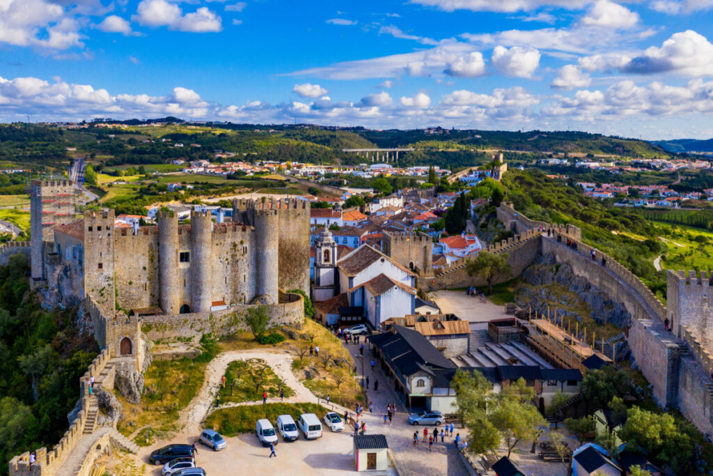 Vista de Óbido em Portugal, com casas brancas, árvores e castelo