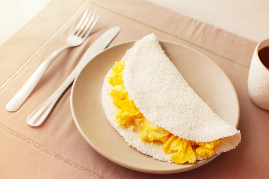 Tapioca com ovo em cima de um prato bege
